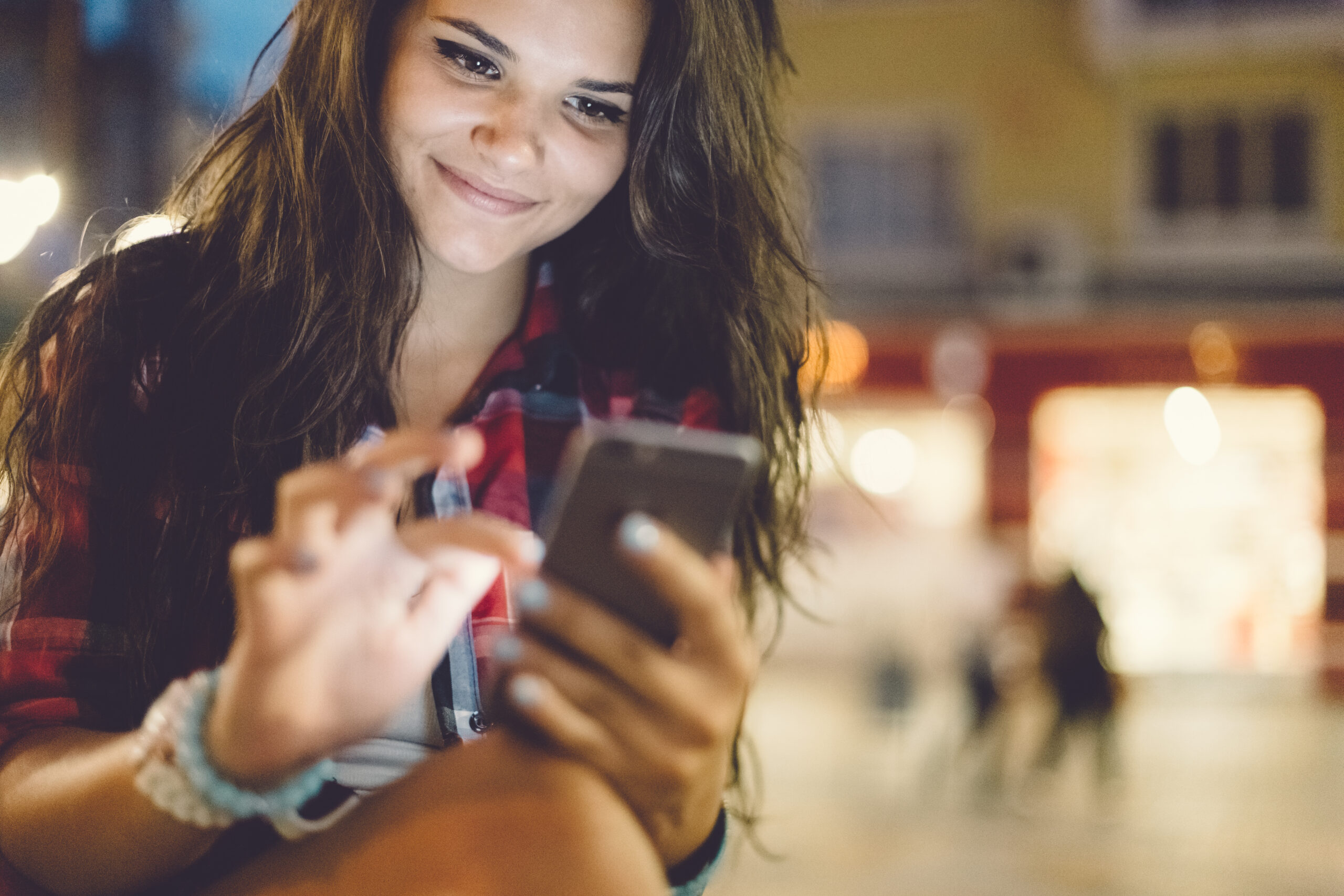 a teen girl scrolls down a smartphone screen